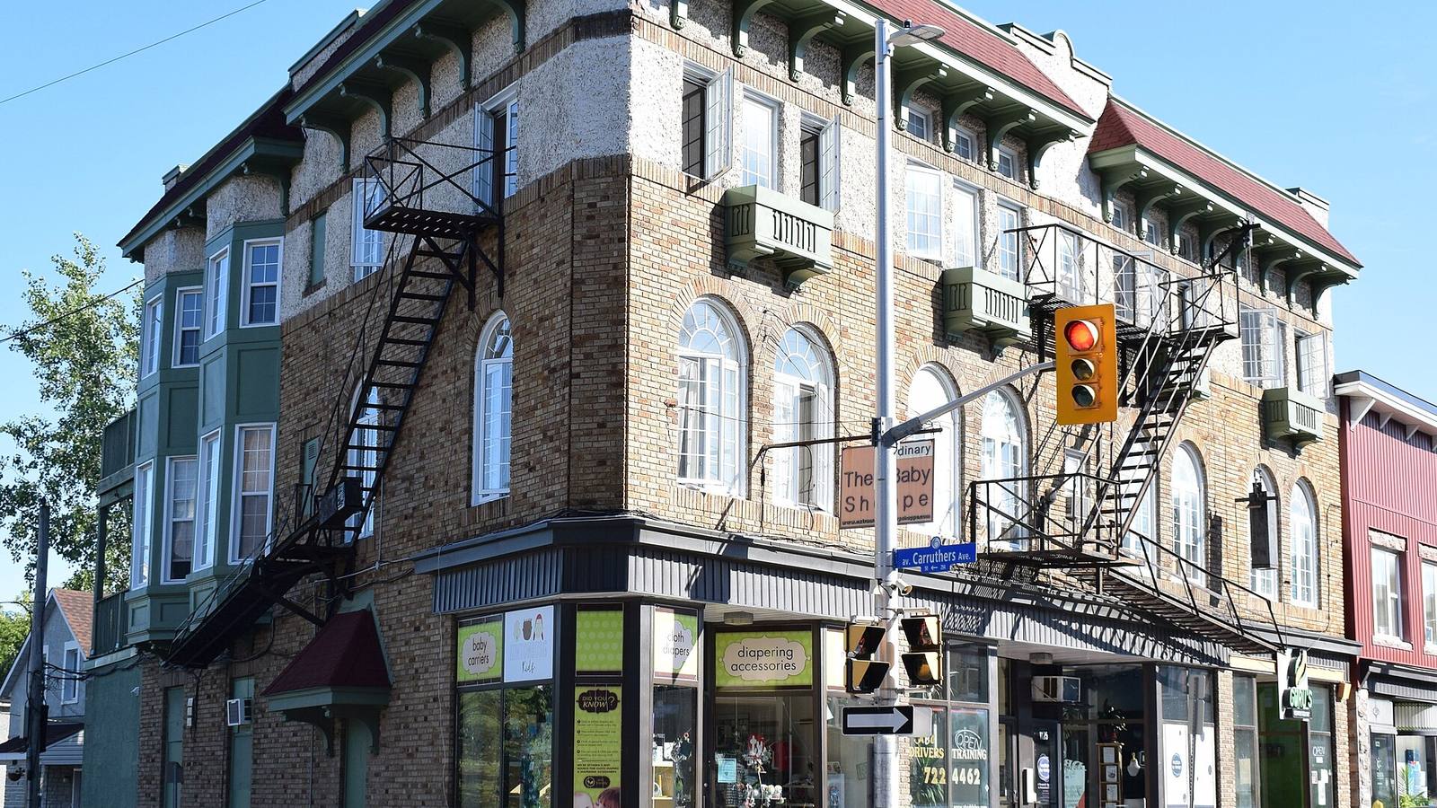 Historic brick corner building with fire escapes on Wellington Street West in Hintonburg